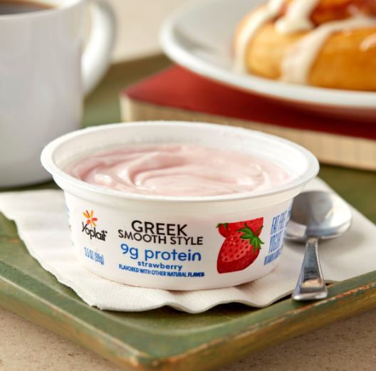 A cup of plain yogurt sits on a breakroom counter, offering a simple, nutritious snack option. It’s a great choice for those looking for a protein-packed, low-sugar treat that can be customized with toppings like fruit or honey for added flavor.