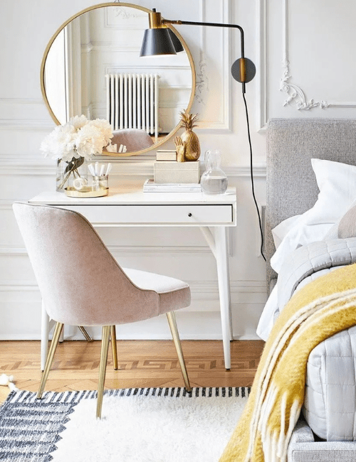 A minimalist white room featuring a simple desk setup with a modern chair and yellow accent pieces.