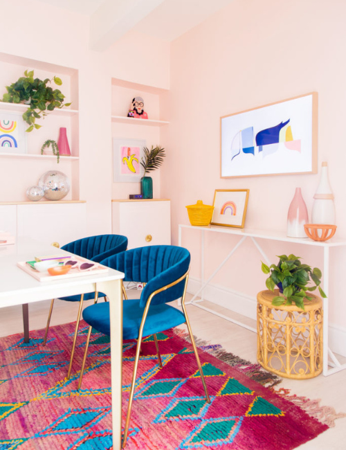 A clean and modern workspace with a white desk and pops of neon in the chair and rug, proving that minimalism and bold colors can coexist beautifully.