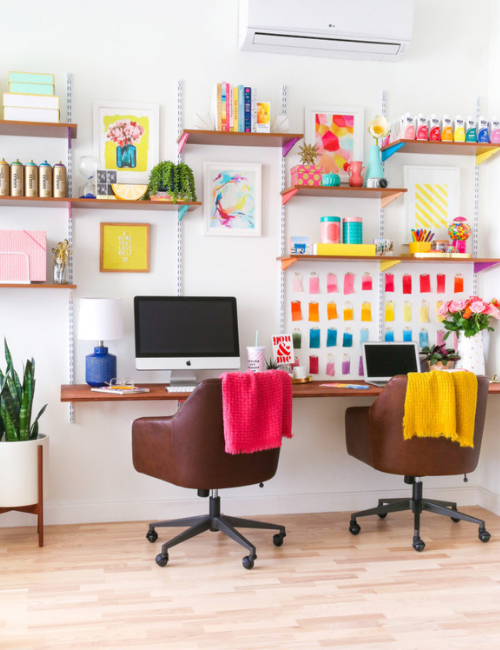 Bright, neon-painted wall shelves provide both storage and a playful touch, making the workspace both efficient and visually exciting.